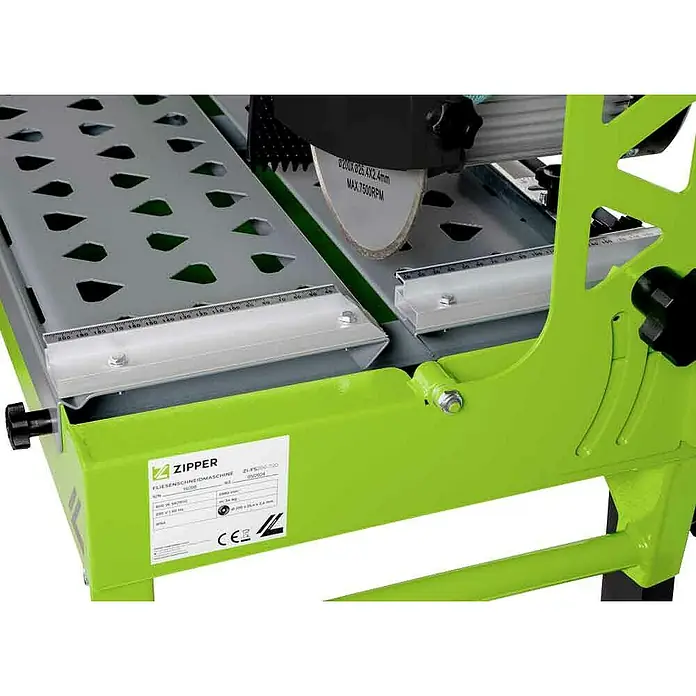 Zipper Elektro-Fliesenschneider ZI-FS200-720 - 500 W, Max. Schnittlänge: 720 mm, Schnitttiefe bei 90 °: 40 mm - Nahaufnahme einer hellgrünen Fliesenschneidmaschine mit grauer perforierter Arbeitsfläche, silbernem Schneidblatt und Messführungen.