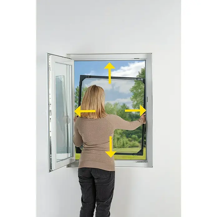 Easy Maxx Insektenschutzfenster - B x H: 115 x 135 cm, Montage Insektengitter: Klemmen, Farbe Rahmen: Anthrazit - Frau montiert einen Insektenschutzrahmen an einem Fenster, um Insekten fernzuhalten. Effektiver Schutz vor Mücken und anderen Insekten.