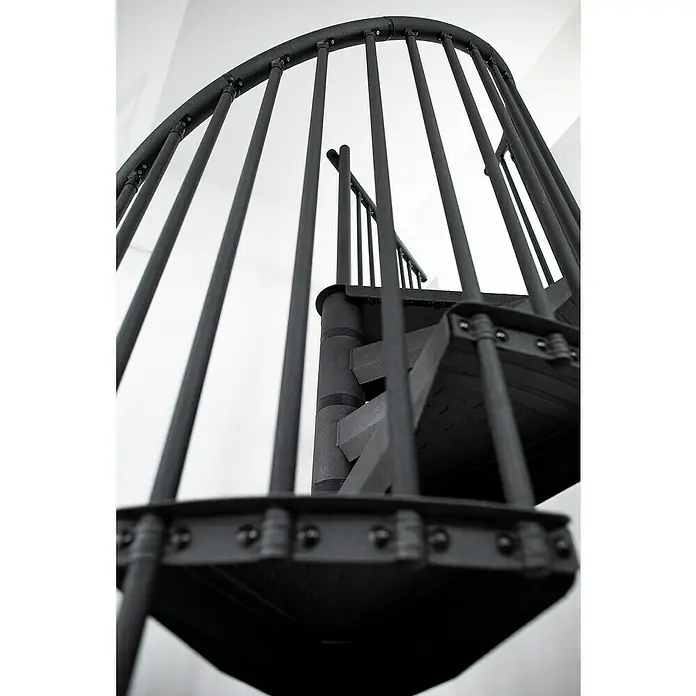 Minka Spindeltreppe Rondo Color - Durchmesser: 160 cm, Anthrazit, Geschosshöhe: 300 cm - Detailaufnahme einer spiralförmigen Wendeltreppe aus dunklem Metall, die sich elegant nach oben windet. Die minimalistische Bauweise betont die Form.