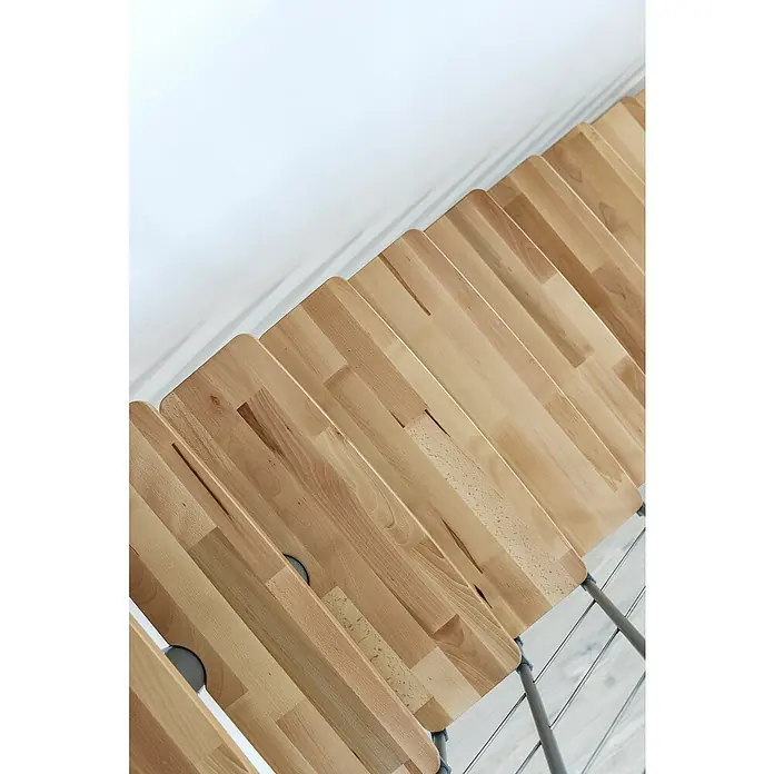 Minka Mittelholmtreppe Comfort Top - Breite: 80 cm, Grau, Farbe Stufen: Buche Natur, Geschosshöhe: 312 cm - Draufsicht auf eine Reihe hellbrauner Holzstühle mit grauem Metallgestell vor einer weißen Wand.