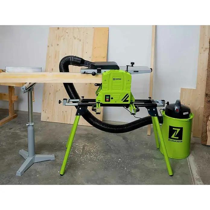 Zipper Abricht-Dickenhobelmaschine ZI-HB204N - Maße Tisch: 740 x 210 mm - Leuchtend grüne Hobelmaschine auf Ständer, bearbeitet ein Holzbrett. Verbunden mit passendem grünen Staubabsauger.