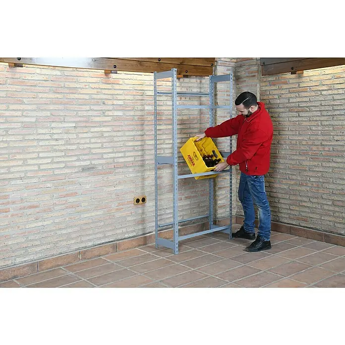 Simonrack Simonbottle Getränkekistenregal Bottleclick - H x B x T: 200 x 80 x 30 cm, Traglast Einlegeboden: 100 kg, Anzahl Böden: 4 Stk., Stecken, Weiß - Mann beim Einräumen eines gelben Getränkekastens mit Bierflaschen in ein graues Metallregal, das an einer Backsteinwand steht.