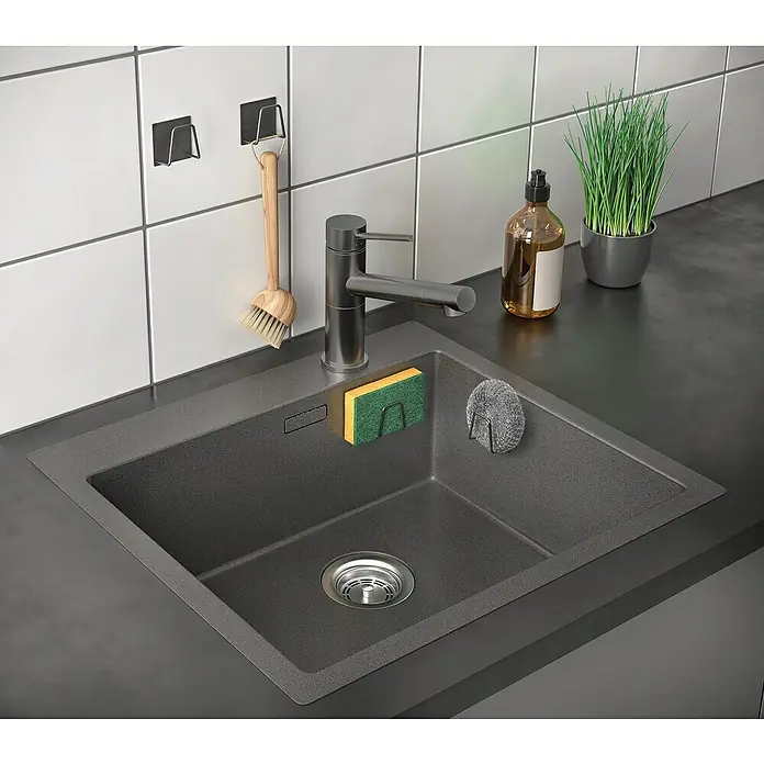Metaltex Schwammkorb Inox - Schwarz, 3 x 5 x 5 cm, Edelstahl - Nahaufnahme einer modernen, grauen Küchenspüle mit Armatur, Spülmittel, Bürste und einem kleinen Topf Gras.