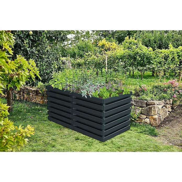 Garantia Hochbeet Skyline L - 161 x 80 x 75 cm, Kunststoff, Graphite Grey - Ein geräumiges Hochbeet aus dunklem Holz mit üppigen Pflanzen in einem Garten. Ideal für den Anbau von Kräutern und Gemüse im Freien.