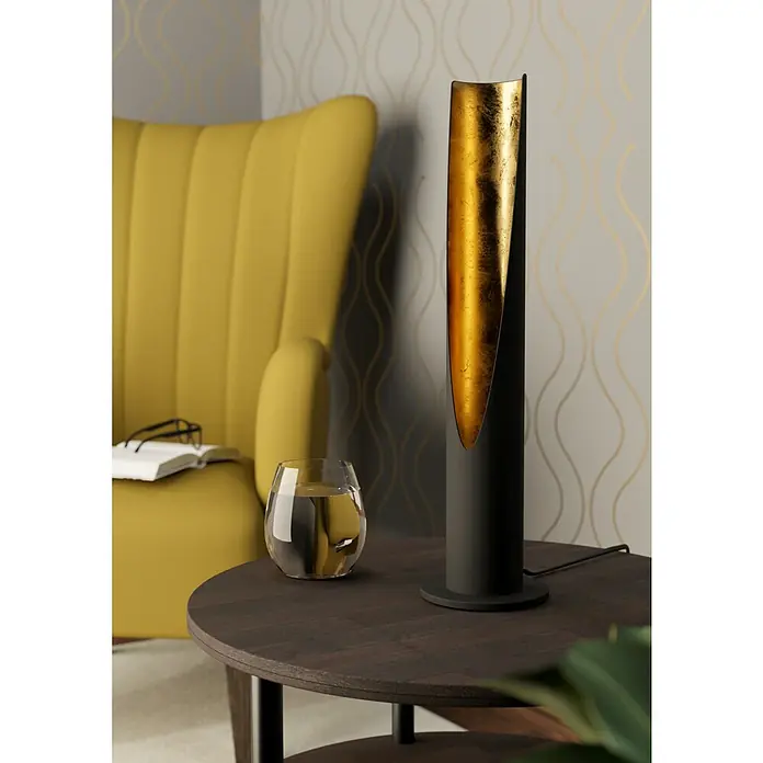 Eglo Barbotto LED-Tischleuchte rund - 5 W, Ø x H: 100 mm x 39,5 cm, Gold, Schwarz, Warmweiß - Elegante Stehlampe mit goldener Innenseite als Akzent auf einem Tisch mit Getränk und Stuhl im Hintergrund.