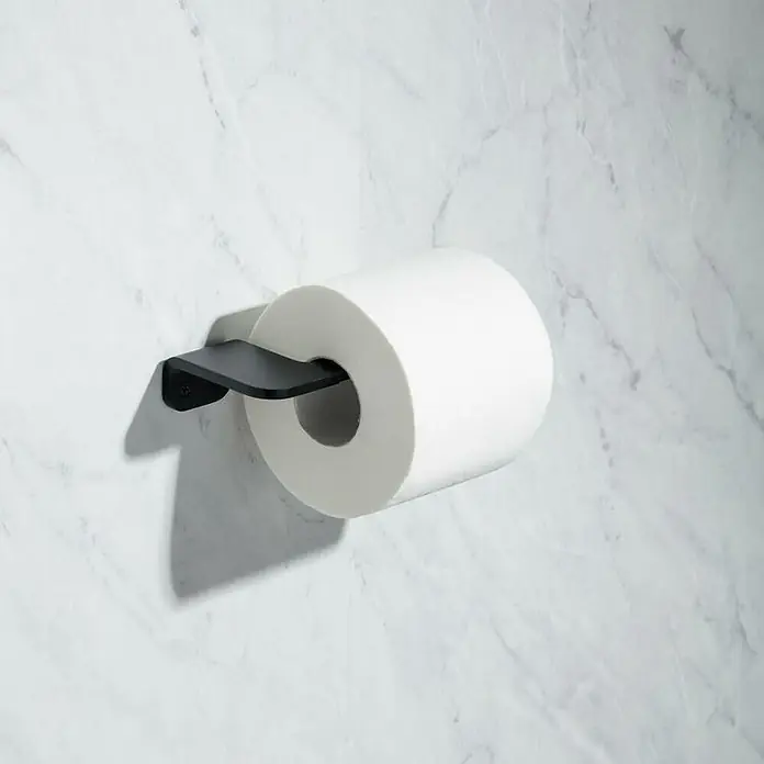 Tatay Onyx Portarrollos papel higiénico - Sin tapa, Negro - Primer plano de un rollo de papel higiénico con un soporte negro en una pared de mármol blanco. El soporte mantiene el papel limpio y ordenado.