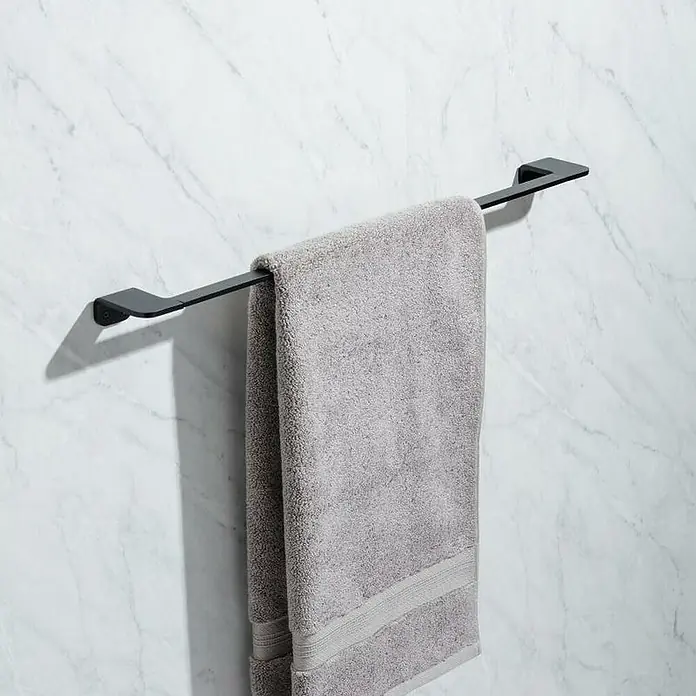Tatay Onyx Toallero de barra - Ancho: 60 cm, Negro - Una toalla gris cuelga de un toallero negro mate contra una pared de mármol.