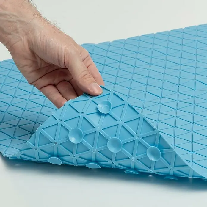 Tatay Antideslizante para bañera Diamond SBS - 54 x 54 cm, Azul - Primer plano de una alfombra de baño turquesa con ventosas, levantada por una mano para mostrar la parte inferior.