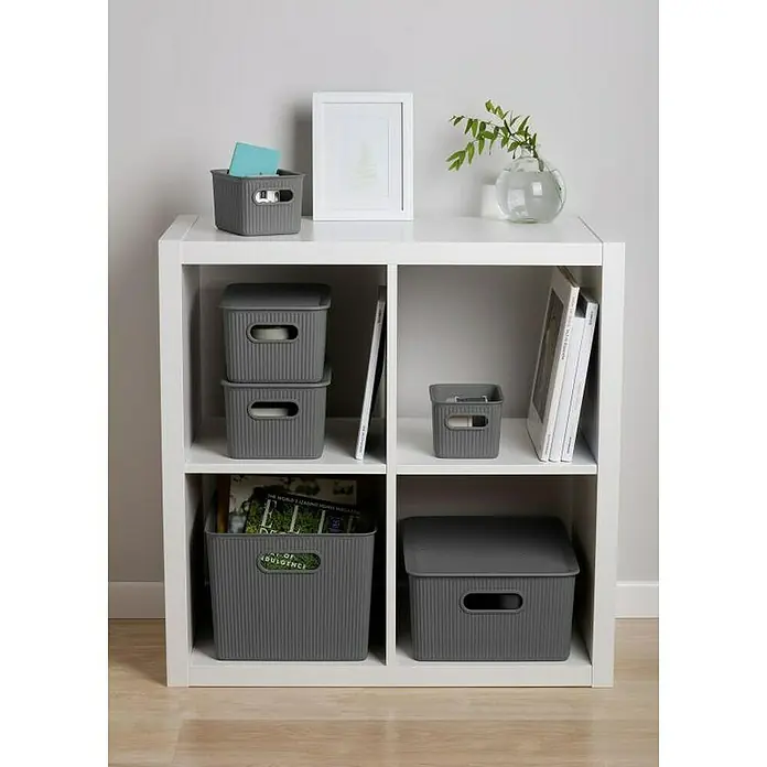 Tatay Baobab Tapa para cesta - 30 x 39 x 0,7 cm, Gris - Una estantería blanca con cajas de almacenamiento grises, libros y elementos decorativos dispuestos con estilo.