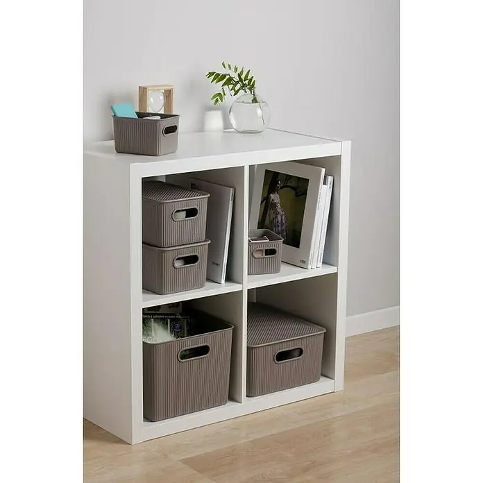 Tatay Baobab Tapa para cesta - 30 x 39 x 0,7 cm, Taupe - Una estantería blanca con cuatro compartimentos, llena de cajas de almacenamiento grises y algunos libros para una organización elegante.