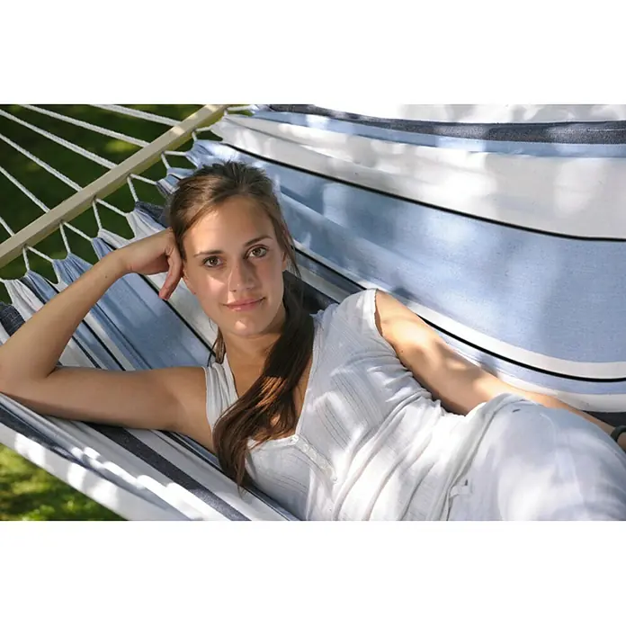 Amazonas Stabhängematte Samba marine - L x B: 210 x 140 cm, Blau/Weiß - Eine Frau entspannt in einer blau-weiß gestreiften Hängematte im Freien. Die Hängematte hängt zwischen zwei Bäumen.