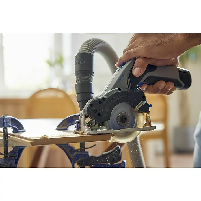 Dremel Akku-Handkreissäge Kompaktsäge Blueprint - 12 V, 1 Akku, 2 Ah, 5.000 U/min - Dremel Akku-Mini-Kreissäge im Einsatz, schneidet Holz mit Staubabsaugung. Ideal für präzise Schnitte bei Hobby- und Handwerksprojekten.