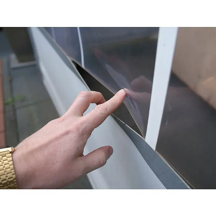 T-Rex Reparaturklebeband All Weather Tape - 25 m x 48 mm - Nahaufnahme einer Hand, die auf ein Solarpanel zeigt, das an einer Wand befestigt ist, mit Fokus auf die Installation der Solartechnologie.