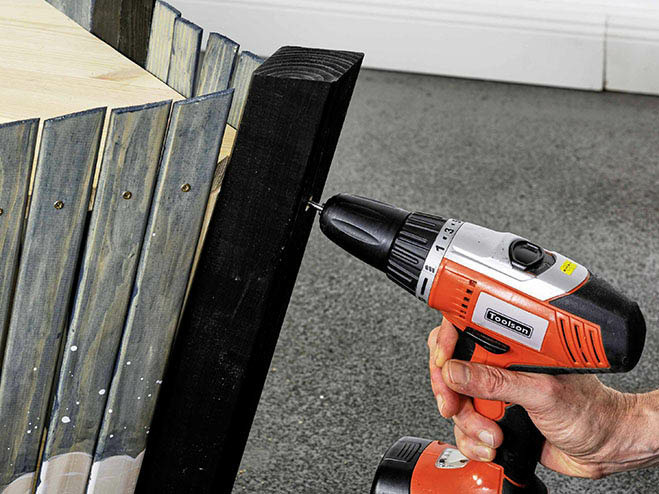 Ein schwarzes Rahmenholz wird an einer Ecke vom DIY Piratenschiff montiert