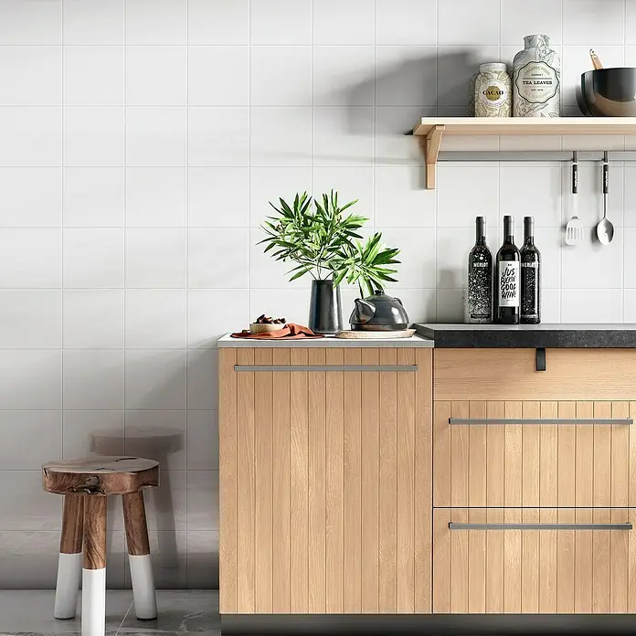 Revestimiento de pared Blanco brillo - 20 x 20 cm, Blanco, Brillante - Escena de cocina con armario de madera, taburete, botellas de vino y elementos decorativos en una estantería, creando un ambiente elegante.