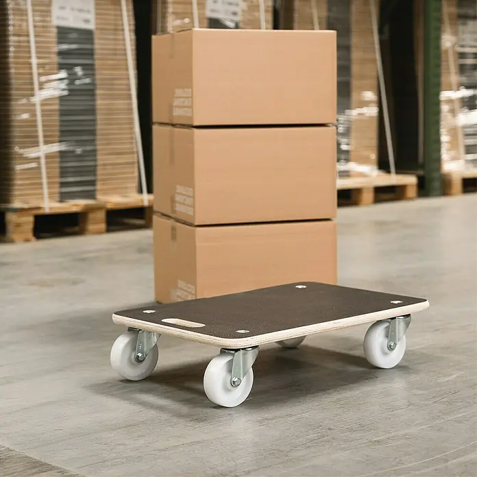 Wagner System Base con ruedas MM 1609 - L x An x Al: 57,5 x 29 x 11 cm, Capacidad de carga: 250 kg, Madera - El patín de muebles marrón con ruedas está en el suelo con cajas al fondo.