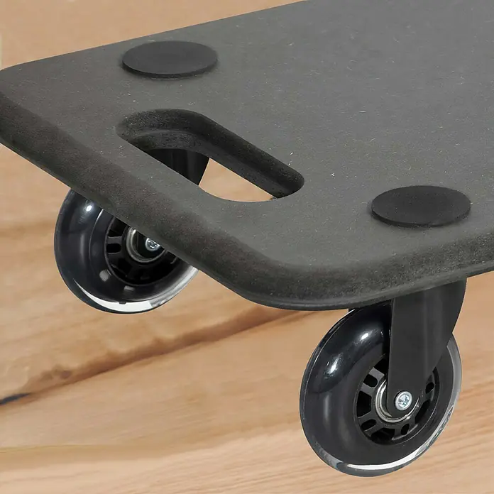 Wagner System Base con ruedas MM 1611 - L x An x Al: 59 x 29 x 11 cm, Capacidad de carga: 250 kg, Madera - Primer plano de una plataforma rodante negra para muebles con ruedas, sobre un suelo de madera. Ideal para facilitar el transporte de muebles.