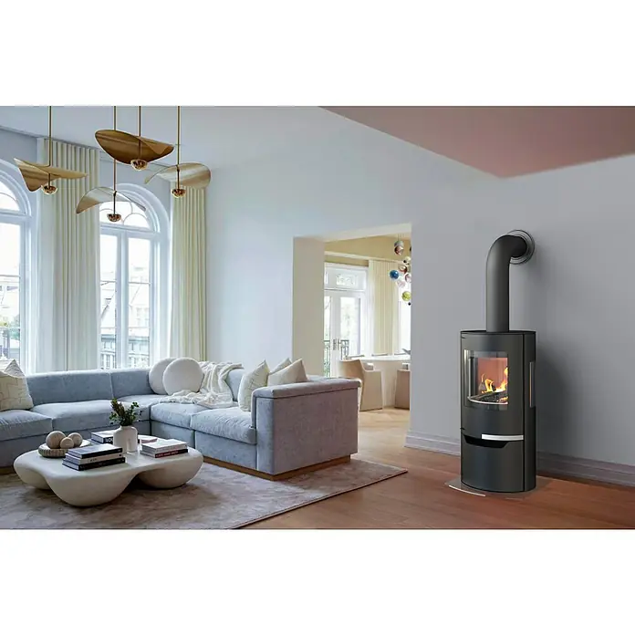 Kaminofen Hiron Trio V2 - 6 kW, Raumheizvermögen: 172 m³, Material Verkleidung: Stahl, Schwarz - Freistehender schwarzer Holzofen mit Glasfront und sichtbarer Flamme, in einem Wohnzimmer.