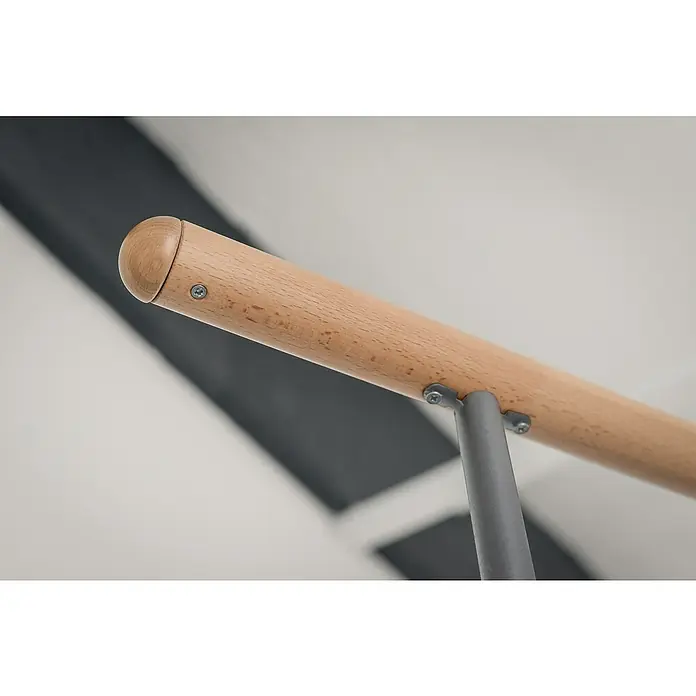 Minka Spindeltreppe Venezia - Durchmesser: 120 cm, Grau, Farbe Stufen: Buche Natur, Geschosshöhe: 305,5 cm - Detailaufnahme einer hölzernen Ballettstange mit grauer Halterung, befestigt mit silbernen Schrauben. Die Ballettstange ist hellbraun.