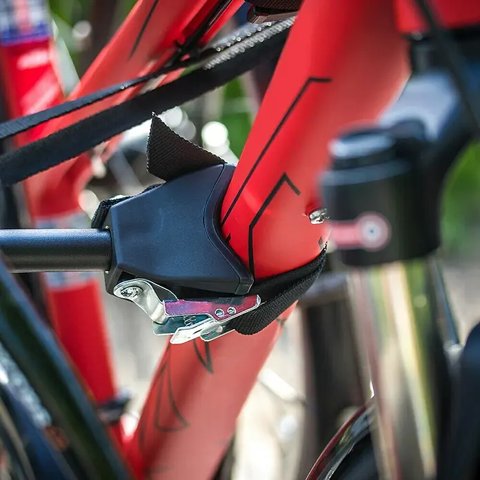 Eufab Fahrradträger Amber IV - Geeignet für: 4 Fahrräder, Passend für: Fahrzeuge mit Anhängerkupplung - Detailaufnahme einer Fahrradhalterung, die am roten Rahmen eines Fahrrads befestigt ist. Solide Konstruktion für sicheren Transport.
