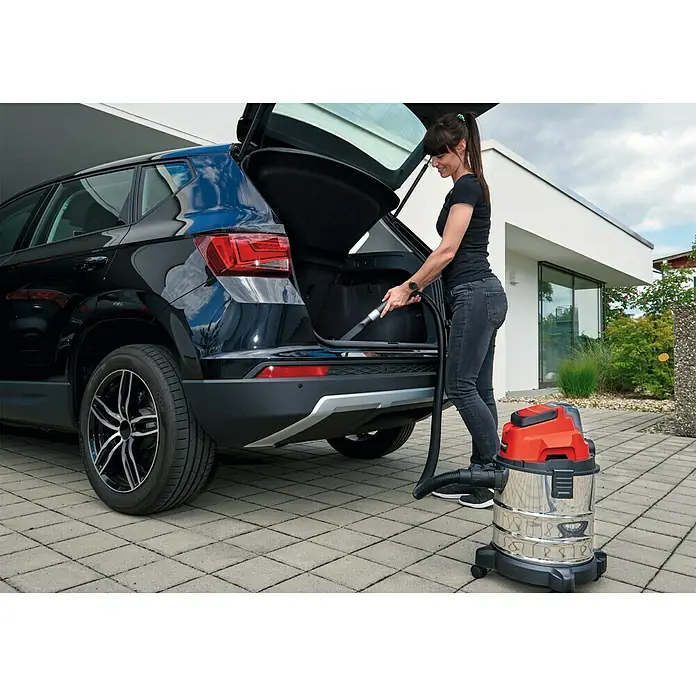 Einhell PXC 18V Akku-Nass-Trockensauger TC-VC 18/20 Li S-Solo - 18 V, Ohne Akku, Behältervolumen: 20 l - Frau saugt den Kofferraum eines Autos mit einem Einhell Nass-Trockensauger, der eine hohe Saugleistung bietet.\n