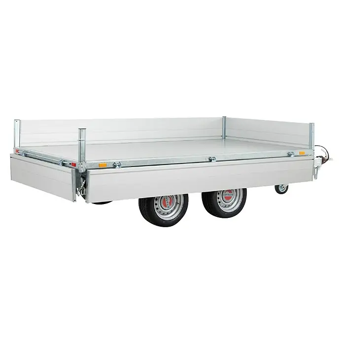Stema Kippanhänger Rocko 2700 Tandem Elektro - Nutzlast: 1.971 kg, Doppelachser, Kasteninnenmaß: 301 × 153 x 30 cm, Gebremst - Hellgrauer Pritschenanhänger mit abklappbaren Bordwänden und zwei Achsen, mit silbernen Rädern mit roten und weißen STEMA-Logos.