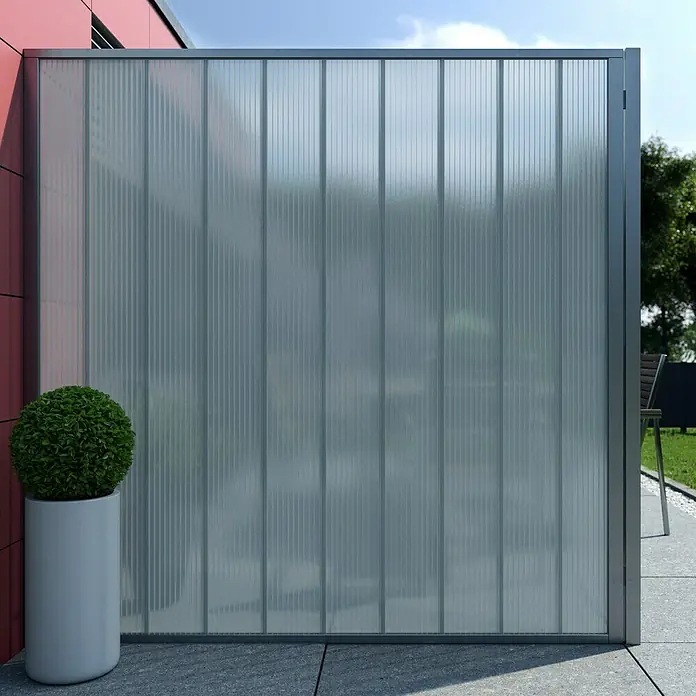 Hohlkammerpaneel - 250 cm x 20 cm x 16 mm, Polycarbonat, Opal - Nahaufnahme einer modernen, geriffelten Glaswand mit grauem Rahmen und einem kugelförmigen Busch in einem weißen Topf.