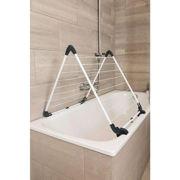 Vileda Stand-Wäscheständer Badewannentrockner Acrobath - Länge Wäscheleine: 10 m, Weiß/Schwarz - Wäscheständer auf Badewanne. Der weiße Wäscheständer mit grauen Akzenten steht auf einer weißen Badewanne vor hellbraunen Fliesen.