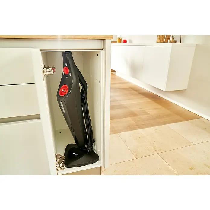 Vileda Steam Dampfreiniger Plus - 3 -tlg., 1 x Dampfreiniger, 2 x Ersatzbezug, 1 x Handbuch, 1 x Teppichgleiter, 1 x 250 ml Messbecher - Ein kompakter Vileda Dampfreiniger steht platzsparend in einem weißen Küchenschrank, bereit für den nächsten Einsatz.