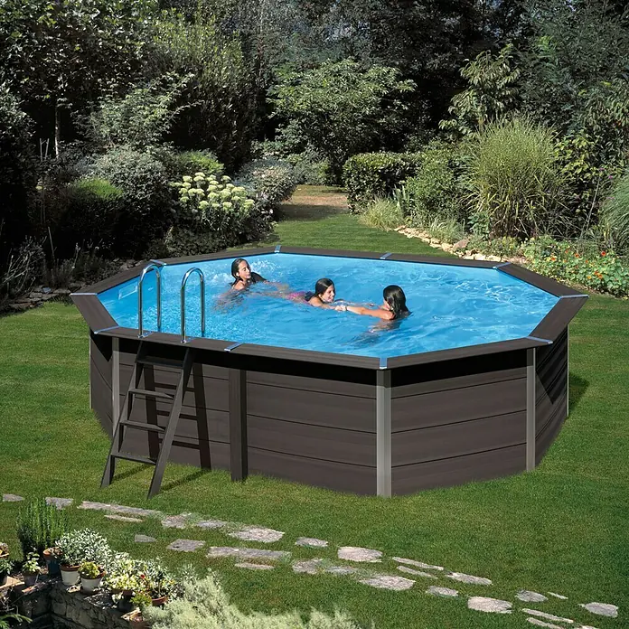 Gre Avantgarde Piscina de WPC KPCOV66 - L x An x Al: 664 x 386 x 124 cm, 21.500 l, Gris oscuro - Una foto exterior de una piscina hexagonal de madera con tres personas dentro, situada en un jardín verde.