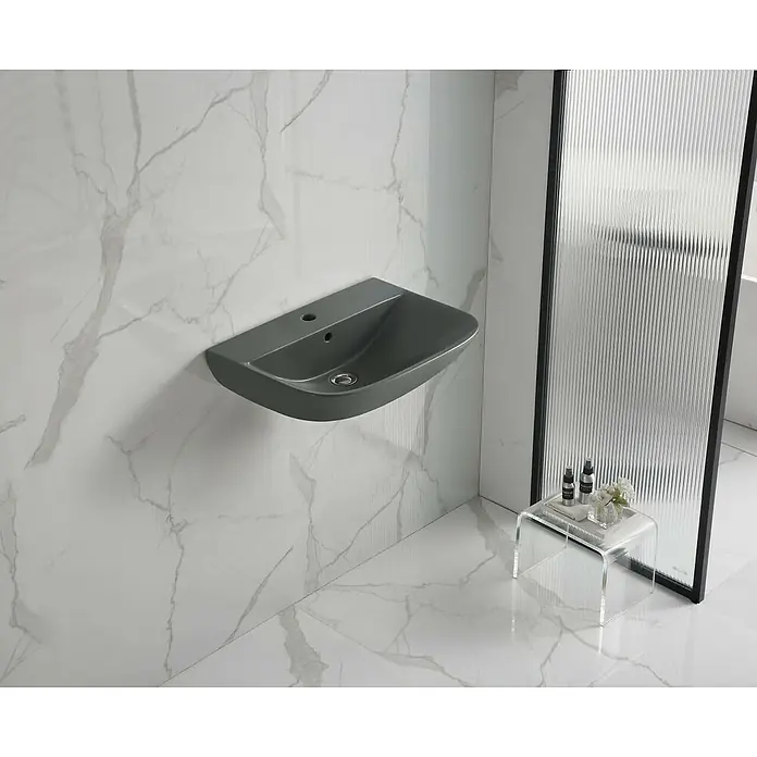 Waschtisch Rivo - 60 x 50 cm, Ohne Spezialglasur, Hahnloch: Mitte, Mit Überlauf, Grau - Graues, wandmontiertes Waschbecken in einem modernen Bad mit weißen Marmorfliesen an Wand und Boden, neben einer Duschabtrennung aus Riffelglas.
