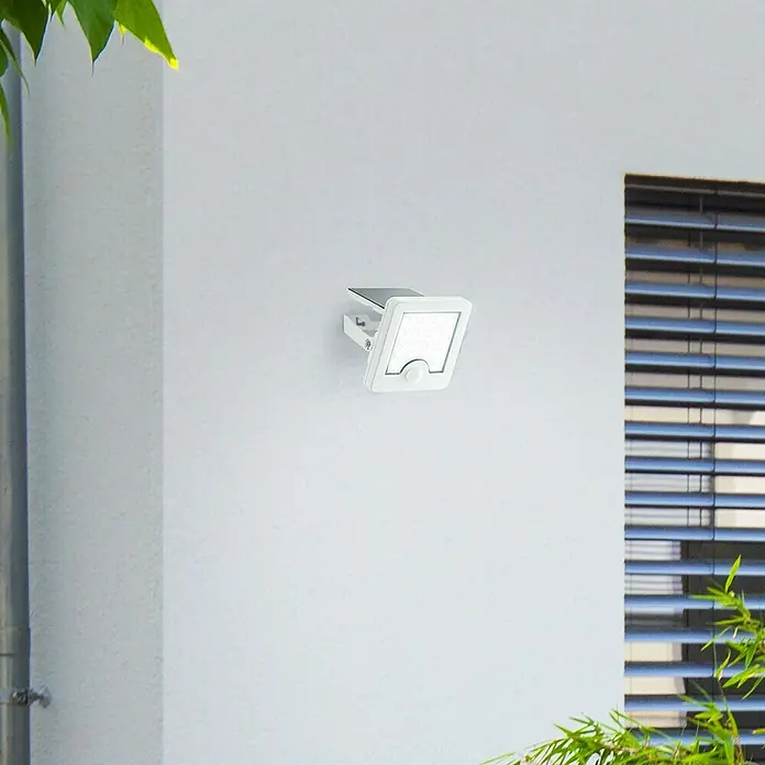 Brilliant Solar-Außenwandleuchte Luton - 4 W, L x B x H: 13 x 12 x 5,4 cm, Weiß, IP65, 540 lm - Weißes Solar-Außenlicht mit Bewegungssensor an einer Wand montiert.