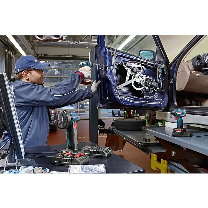 Bosch Professional AMPShare 18V Akku-Drehschlagschrauber GDR 12V-110 - 12 V, Ohne Akku - Ein Mechaniker repariert eine Autotür mit einem Bosch Akku-Bohrschrauber. Im Vordergrund sind Bosch Werkzeuge zu sehen.