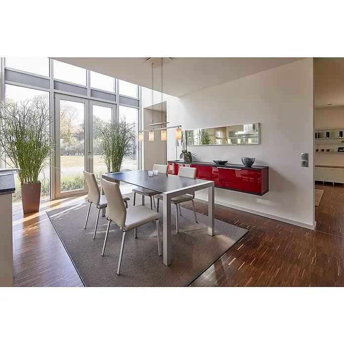 Voltomat DIVA Wechselschalter - Platin, Glänzend, Unterputzmontage, 10 A - Moderner Essbereich mit dunklem Tisch, vier hellen Stühlen auf Teppich, rotem Sideboard und großen Fenstern.