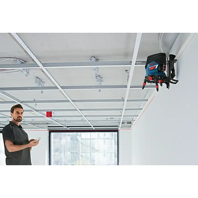 Bosch Professional Universalhalterung - Blau/Scharz/Rot, Passend für: GCL 2-50 C, GCL 2-50 CG - Das Bild zeigt einen Bosch GCL 2-50 G Professional Linienlaser im Einsatz auf einer Baustelle zur präzisen Ausrichtung.