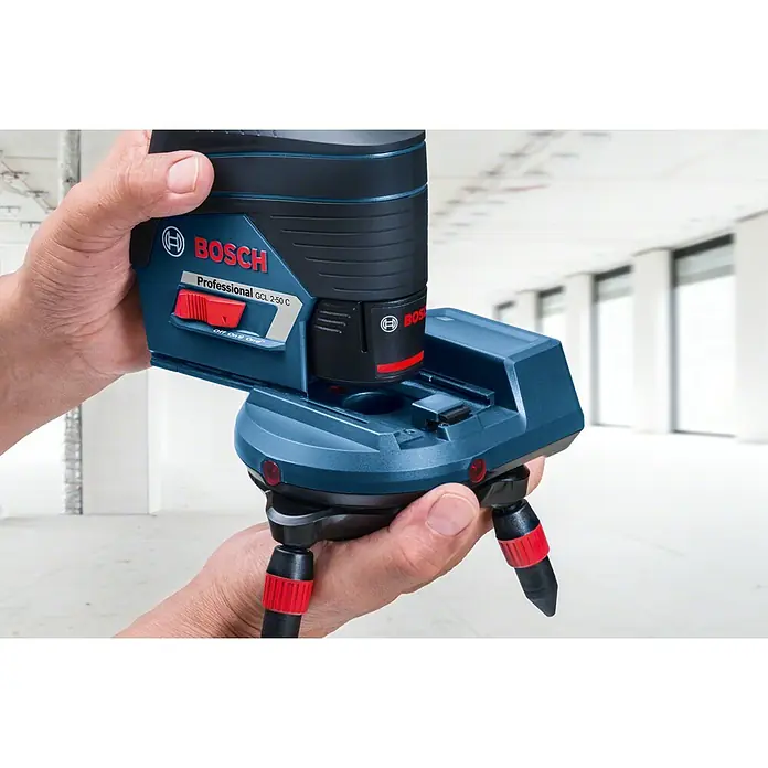 Bosch Professional Universalhalterung - Blau/Scharz/Rot, Passend für: GCL 2-50 C, GCL 2-50 CG - Blau-schwarzer Bosch Professional GCL 2-50 C Kreuzlinienlaser mit integriertem Stativ, in einer Hand in Innenräumen gehalten.
