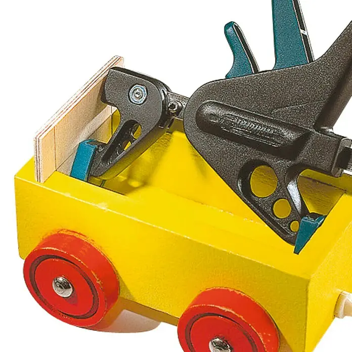 Wolfcraft Einhandzwinge EHZ - Spannweite: 110 mm, Spannkraft: 295 N, Ausladung: 38 mm - Eine gelbe Spielzeugkiste mit roten Rädern wird mit einer schwarzen Klemme bearbeitet, um Stabilität zu gewährleisten.