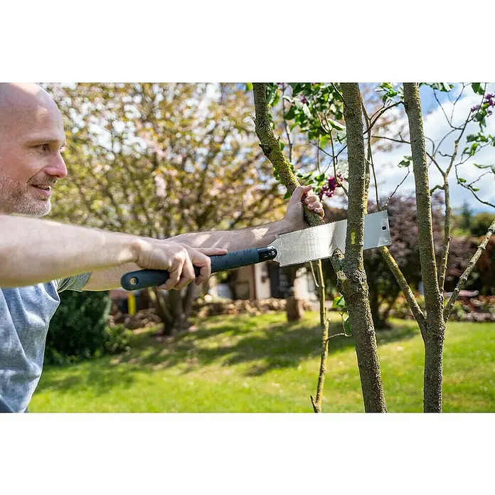 Wolfcraft Japansäge - Blattlänge: 330 mm - Ein Mann benutzt eine Handsäge, um im Garten einen Ast an einem Baum zu beschneiden. Die Astsäge ist ein nützliches Werkzeug für Gartenarbeiten.