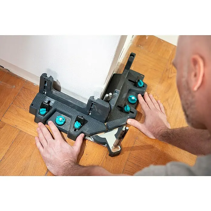 Wolfcraft Gehrungsschneidlade & Schmiege - Kunststoff - Ein Mann benutzt eine Gehrungslade für präzise Winkelschnitte von Holzleisten. Das Werkzeug ist auf einem Holzboden positioniert.