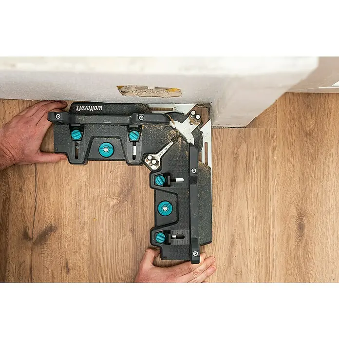Wolfcraft Gehrungsschneidlade & Schmiege - Kunststoff - Eine Wolfcraft-Montageeisen-Eckspannvorrichtung zum präzisen Ausrichten von Laminatpaneelen an einer Ecke mit Bohlenmuster.