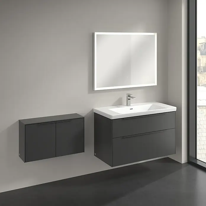 Villeroy & Boch Subway 3.0 Seitenschrank - B x T x H: 72,8 x 25,6 x 42,3 cm, Graphite, DIN Anschlag: Links/Rechts, Farbe Griff: Monochrom - Dunkelgrauer Badschrank mit weißem Waschbecken, Chromarmatur und beleuchtetem Spiegel. Passender Hängeschrank daneben.