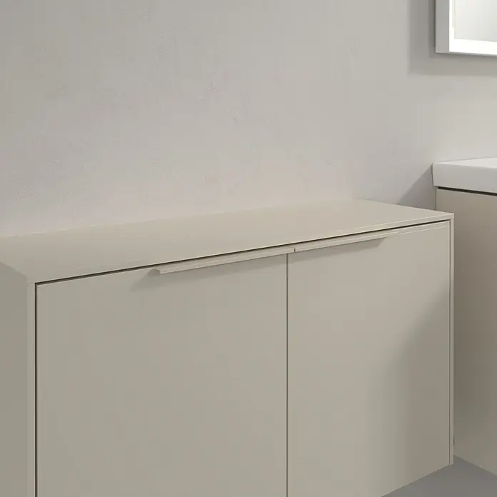 Villeroy & Boch Subway 3.0 Seitenschrank - B x T x H: 72,8 x 25,6 x 42,3 cm, Cashmere Grey, DIN Anschlag: Links/Rechts, Farbe Griff: Monochrom - Heller beiger Badschrank mit zwei Türen und integrierten Griffen vor einer hellen Wand.