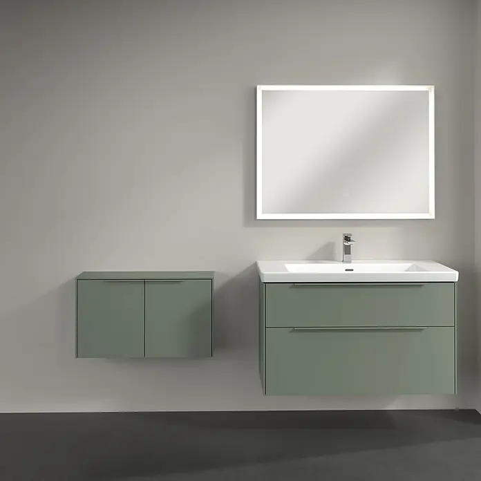 Villeroy & Boch Subway 3.0 Seitenschrank - B x T x H: 72,8 x 25,6 x 42,3 cm, Soft Green, DIN Anschlag: Links/Rechts, Farbe Griff: Monochrom - Salbeigrüner Badunterschrank mit Waschbecken, Chromarmatur, zwei Schubladen und passendem Wandschrank. Darüber hängt ein beleuchteter, rechteckiger Spiegel.