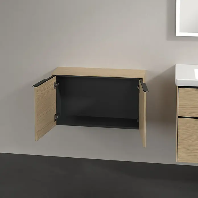Villeroy & Boch Subway 3.0 Seitenschrank - B x T x H: 72,8 x 25,6 x 42,3 cm, Nordik Oak, DIN Anschlag: Links/Rechts, Farbe Griff: Volcano Black - Wandhängender heller Holzschrank mit zwei geöffneten Türen, dunklem Inneren und schwarzen Griffen, neben einem Waschtisch.