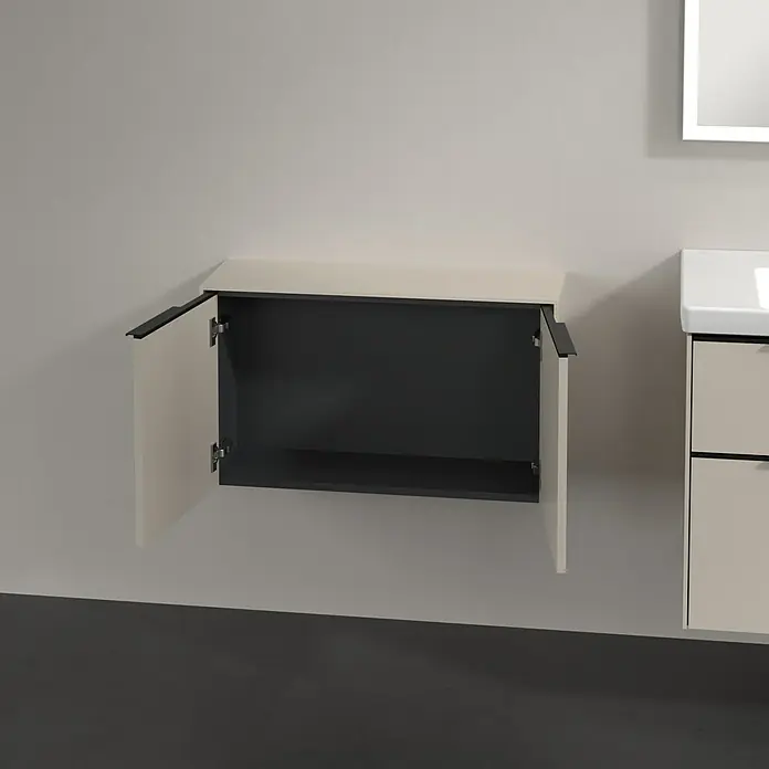 Villeroy & Boch Subway 3.0 Seitenschrank - B x T x H: 72,8 x 25,6 x 42,3 cm, Cashmere Grey, DIN Anschlag: Links/Rechts, Farbe Griff: Volcano Black - Wandmontierter hellbeiger Schrank mit dunklen Griffen und offenen Türen, der ein dunkles Inneres zeigt.