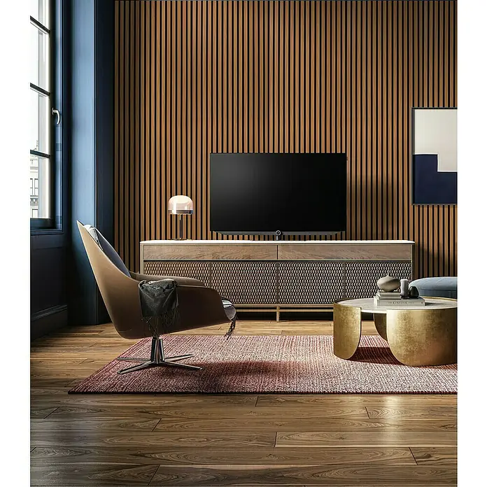 Panel acústico decorativo - 244 x 60,5 x 2,2 cm, Roble - Elegante salón con un televisor moderno, muebles elegantes y una cálida alfombra, creando un ambiente acogedor.