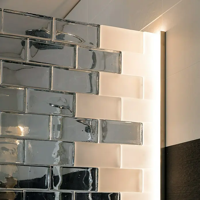 Fuchs Design Glasziegel Crystal Collection - Klar, Seidenmatt, 10 x 10 x 5 cm - Nahaufnahme von Glasfliesen in Grau und Weiß, die ein modernes und stilvolles Designelement darstellen. Die glänzende Oberfläche reflektiert das Licht.