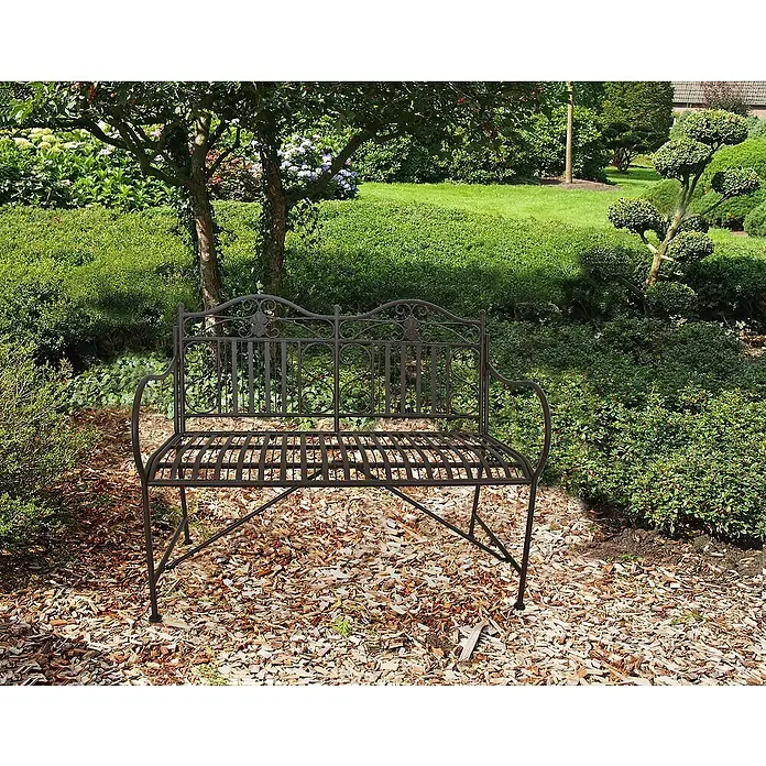 Garden Pleasure Gartenbank Mangan - B x T x H: 106 x 57 x 91 cm, Stahl, Schwarz-Braun - Dunkelbronzene Metall-Gartenbank mit verschnörkelter Rückenlehne, auf Holzspänen in einem üppigen Garten.