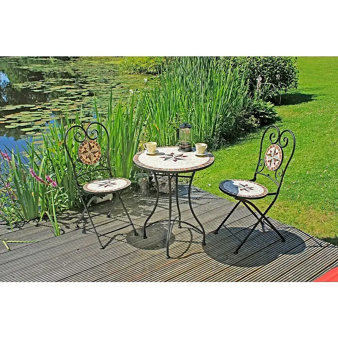 Garden Pleasure Balkonmöbel-Set Amarillo - 3 -tlg., Schmiedeeisen, Keramik, Weiß/Braun/Ocker, Klappbar - Bistro-Set mit rundem Mosaiktisch und zwei Stühlen mit sternförmigen Mosaikdetails, aus schwarzem Schmiedeeisen, auf Holzterrasse an Teich.