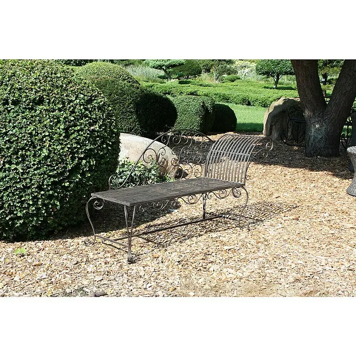 Garden Pleasure Gartenbank Lamington - B x T x H: 163 x 47,5 x 93 cm, Stahl, Schwarz-Braun - Eine verzierte, dunkelgraue Metallgartenbank mit Rankenornamenten, auf Holzspänen neben einem grünen Busch in einem sonnigen Garten.